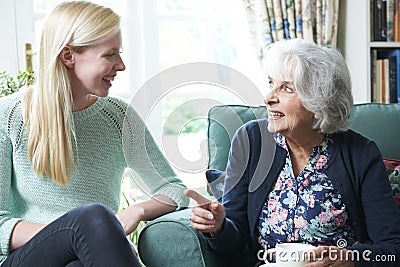 Teenage Granddaughter Visiting Grandmother Stock Photo