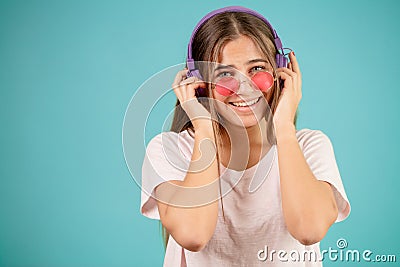 Teenage with grey eyes touching her headphones on her head Stock Photo