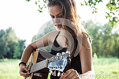 Guitarist adjusting tuning pegs Stock Photo