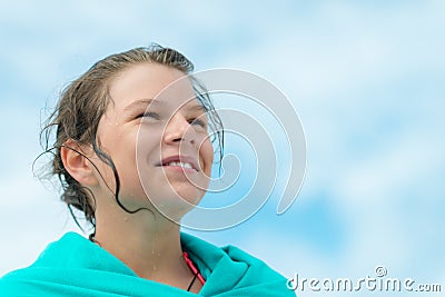 Teenage laughing girl wrapped in a turquoise towel Stock Photo