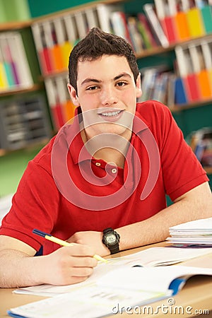 Teenage Male Student In Working In Classroom Stock Photo