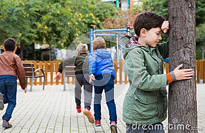 Teenage playing hide-and-go-seek in the playground Stock Photo