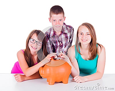Teenage putting coins into big piggy bank Stock Photo