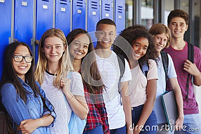 Teenage school kids smiling to camera in school corridor Stock Photo
