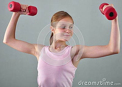 Teenage sportive girl is doing exercises to develop muscles on grey background. Sport healthy lifestyle concept. Sporty Stock Photo