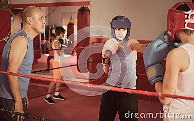 Teenage sportsman at boxing workout with coach Stock Photo