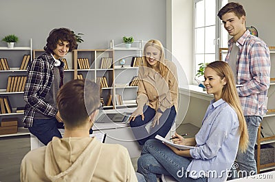 Teenage student group having friendly talk during rest on break in classroom Stock Photo