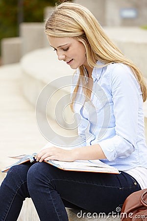 Teenage student reading outdoors Stock Photo