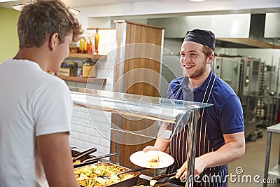 Teenage Students Being Served Meal In School Canteen Stock Photo