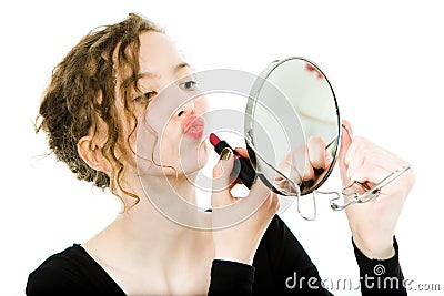 Teenaged girl in black dress making make up in round mirror - lipstick Stock Photo
