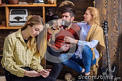 Teenager absorbed with gadget and not talking to parents, generation gap, rebellious youth concept. Bearded man and Stock Photo