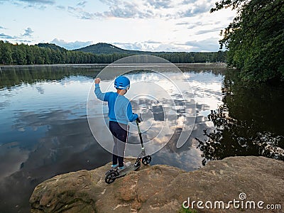 Teenager boy in a blue helmet stay at push scooter Stock Photo