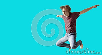 Teenager boy jumping dance movement on a colored blue background Stock Photo