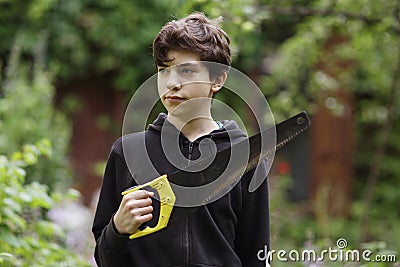 Teenager boy with saw going to do housekeeping job close up photo Stock Photo