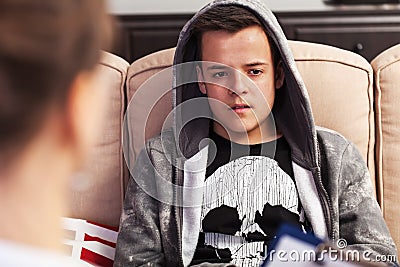 Teenager boy sitting at counseling - in front of the therapy professional, close up Stock Photo