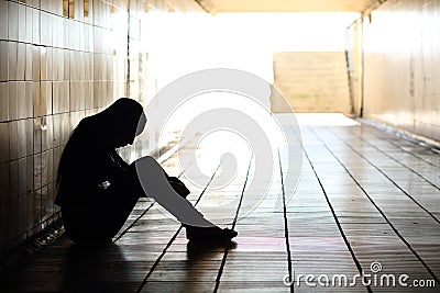 Teenager depressed sitting inside a dirty tunnel Stock Photo