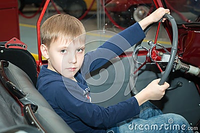 The teenager driving the car in the Museum of technology Stock Photo