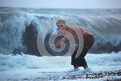 Teenager escaping from sea wave Stock Photo