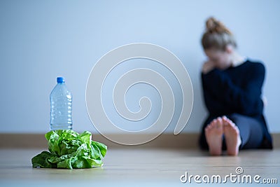 Girl with anorexia nervosa being on restricted diet of water and salad Stock Photo