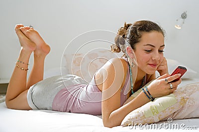 Teenager girl bed cell phone Stock Photo