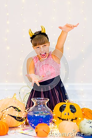 Teenager girl in demon costume posing with pumpkins Stock Photo