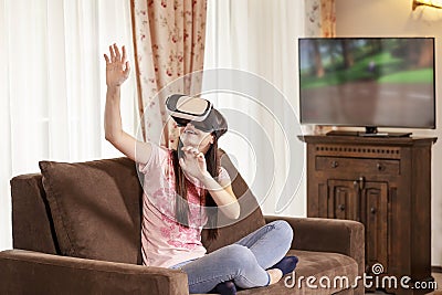 Teenager girl having fun with virtual reality glasses at home Stock Photo