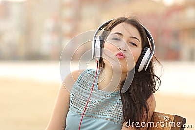 Teenager girl with headphones kissing at camera Stock Photo