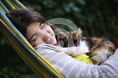 Teenager girl nap in hammock with little kitten Stock Photo
