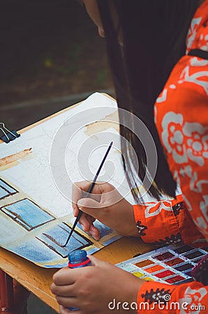 A teenager girl paints a picture with watercolors. Stock Photo