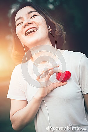 Teenager girl smile with love heart listening music Stock Photo