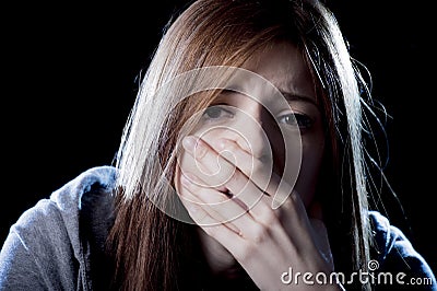 Teenager girl in stress and pain suffering depression sad and scared in fear face expression Stock Photo