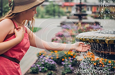 Teenager girl washes hand in fountain Stock Photo