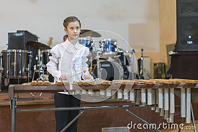 Teenager girl in a white shirt boy playing the marimba Stock Photo