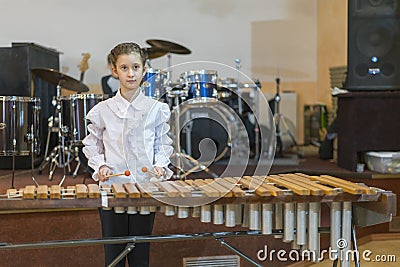 Teenager girl in a white shirt boy playing the marimba Stock Photo