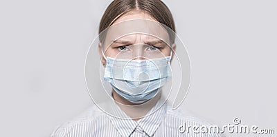 Teenager girl 12-13 years old, face covered with medical mask, close-up portrait, chagrin and serious look, tired and Stock Photo