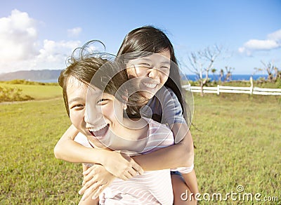 Teenager girls playing piggyback and having fun Stock Photo