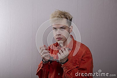 A teenager in handcuffs on a gray background. juvenile delinquents in quarantine, criminal liability. Members of youth criminal gr Stock Photo