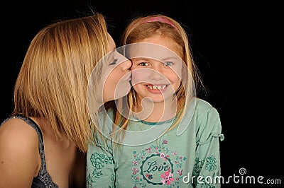 Teenager kissing young sister Stock Photo