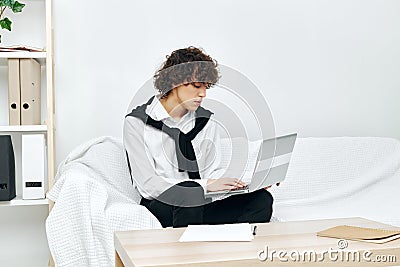 teenager laptop sitting on white sofa online training living room Stock Photo