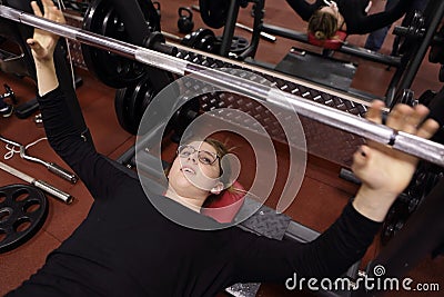 Teenager lifting barbell with weight Stock Photo