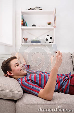 Teenager messaging online on smartphone in living room at home Stock Photo