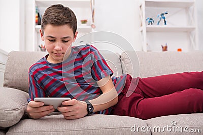 Teenager messaging online on smartphone in living room at home Stock Photo