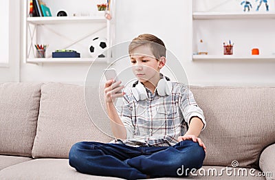 Teenager messaging online on smartphone in living room at home Stock Photo