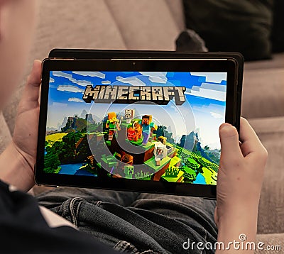 Teenager playing Minecraft on a tablet shallow depth of field Editorial Stock Photo