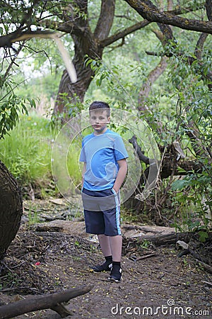 A teenager poses for a photographer while walking in the park. Stock Photo