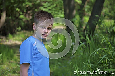 A teenager poses for a photographer while walking in the park. Stock Photo