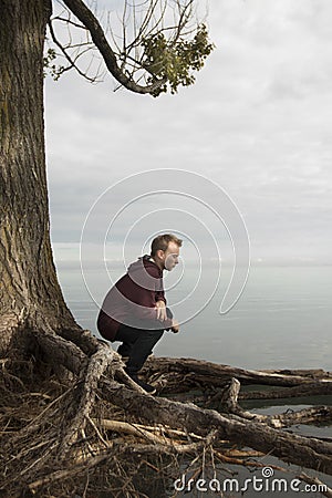 Teenager praying in solitude near lake Stock Photo