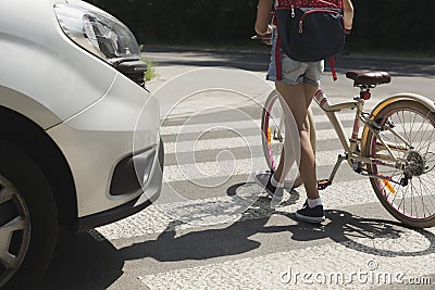 Teenager school girl with backpack and bike walk in pedestrian crossing Stock Photo