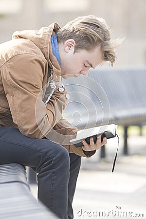 Teenager sitting on bench and praying Stock Photo
