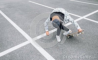 Teenager skateboarder boy with a skateboard on asphalt playground doing tricks. Youth generation Freetime spending concept image Stock Photo